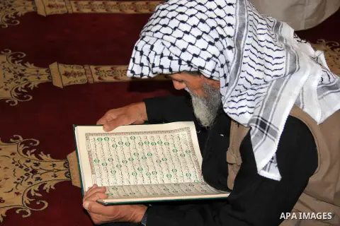 A Palestinian man reads the Koran, Islam's holy book, at al-Aqsa mosque during the holy month of Ramadan, in Jerusalem's old city on June 14, 2016. Ramadan is sacred to Muslims because it is during that month that tradit...