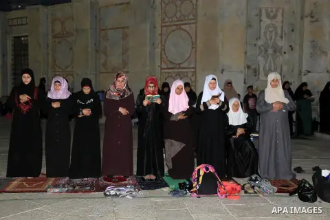 Palestinian women perform "Taraweeh", nightly prayer of the month of Ramadan, in front of the Dome of the Rock mosque, in Jerusalem's old city on June 14, 2016. Ramadan is sacred to Muslims because it is during that mont...