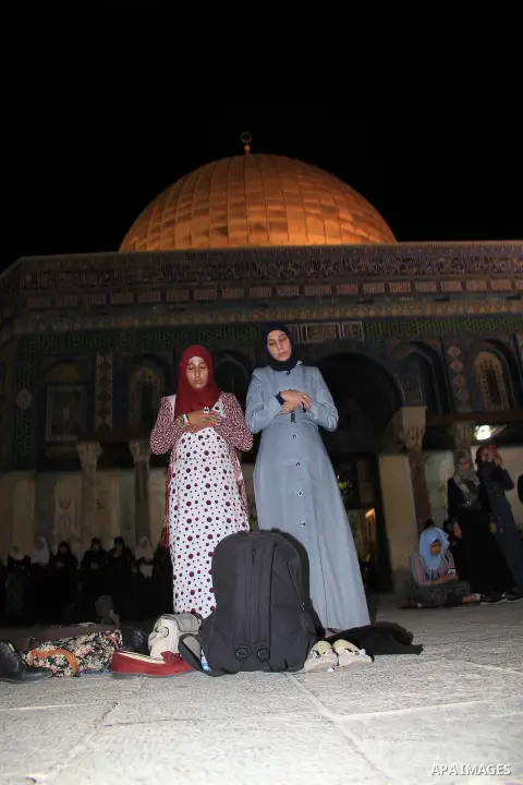 Palestinian women perform "Taraweeh", nightly prayer of the month of Ramadan, in front of the Dome of the Rock mosque, in Jerusalem's old city on June 14, 2016. Ramadan is sacred to Muslims because it is during that mont...