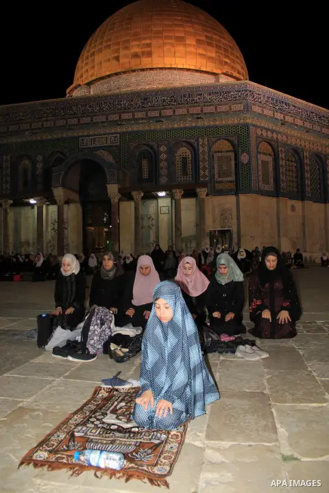 Palestinian women perform "Taraweeh", nightly prayer of the month of Ramadan, in front of the Dome of the Rock mosque, in Jerusalem's old city on June 14, 2016. Ramadan is sacred to Muslims because it is during that mont...