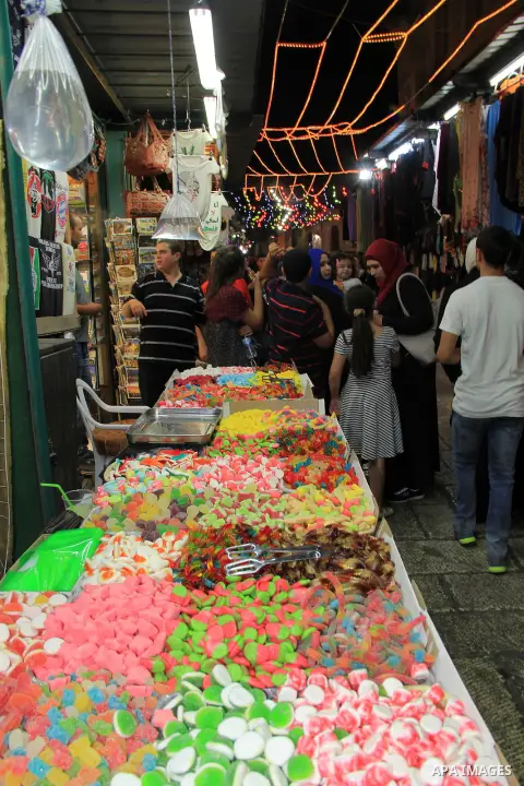 Palestinians shop at a market following "Taraweeh", nightly prayer of the month of Ramadan, at al-Aqsa mosque, in Jerusalem's old city on June 14, 2016. Ramadan is sacred to Muslims because it is during that month that t...
