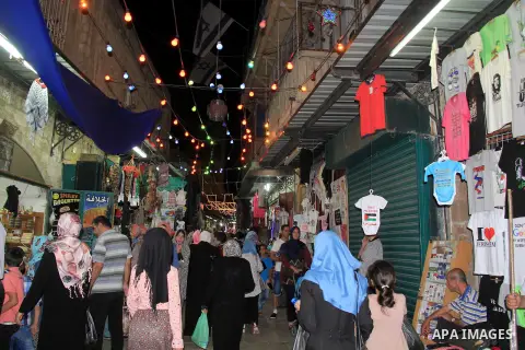 Palestinians shop at a market following "Taraweeh", nightly prayer of the month of Ramadan, at al-Aqsa mosque, in Jerusalem's old city on June 14, 2016. Ramadan is sacred to Muslims because it is during that month that t...
