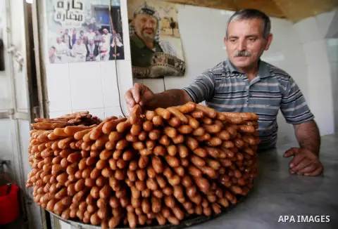 A Palestinian vendor prepares traditional sweets called "awwamah" at his shop at a market during the holy month of Ramadan in the West Bank city of Nablus, on June 15, 2016. Ramadan is sacred to Muslims because it is dur...