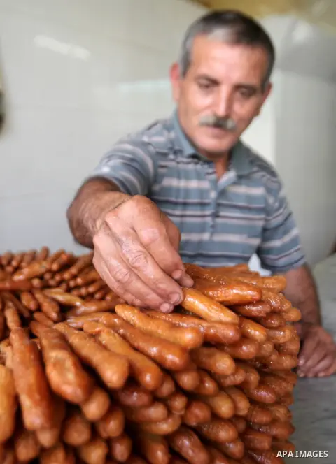 A Palestinian vendor prepares traditional sweets called "awwamah" at his shop at a market during the holy month of Ramadan in the West Bank city of Nablus, on June 15, 2016. Ramadan is sacred to Muslims because it is dur...