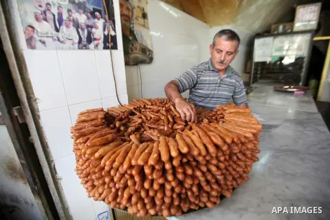 A Palestinian vendor prepares traditional sweets called "awwamah" at his shop at a market during the holy month of Ramadan in the West Bank city of Nablus, on June 15, 2016. Ramadan is sacred to Muslims because it is dur...