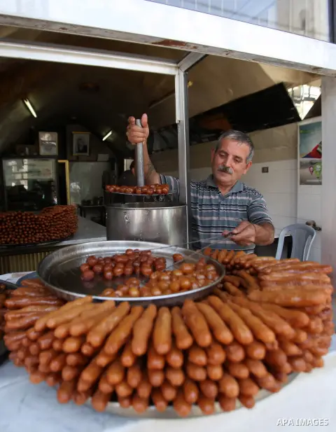 A Palestinian vendor prepares traditional sweets called "awwamah" at his shop at a market during the holy month of Ramadan in the West Bank city of Nablus, on June 15, 2016. Ramadan is sacred to Muslims because it is dur...