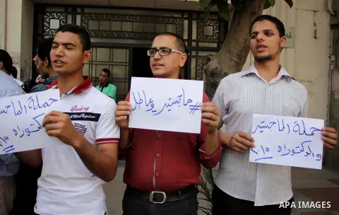 Egyptians Who obtained master's degree hold placards and shout slogans during a protest to demand jobs in Cairo, Egypt, on June 15, 2016. Photo by Amr Sayed