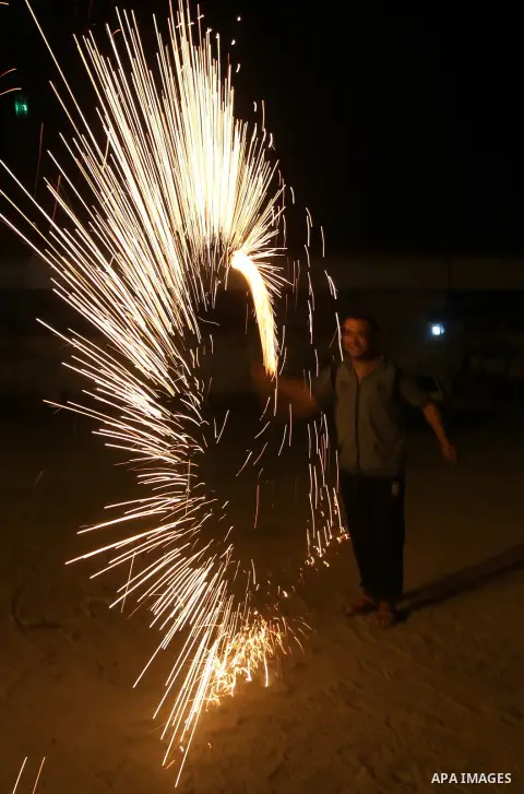 A Palestinian boy plays with fire crackers at street celebrating on the holy month of Ramadan in Rafah in the southern Gaza strip, on June 15, 2016. Ramadan is sacred to Muslims because it is during that month that tradi...