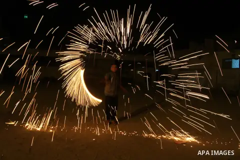 A Palestinian boy plays with fire crackers at street celebrating on the holy month of Ramadan in Rafah in the southern Gaza strip, on June 15, 2016. Ramadan is sacred to Muslims because it is during that month that tradi...