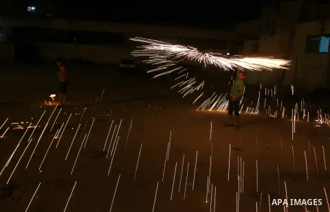 A Palestinian boy plays with fire crackers at street celebrating on the holy month of Ramadan in Rafah in the southern Gaza strip, on June 15, 2016. Ramadan is sacred to Muslims because it is during that month that tradi...