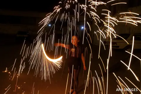 A Palestinian boy plays with fire crackers at street celebrating on the holy month of Ramadan in Rafah in the southern Gaza strip, on June 15, 2016. Ramadan is sacred to Muslims because it is during that month that tradi...