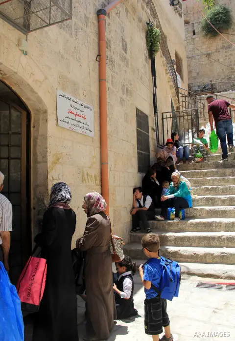 Palestinian families wait to receive a charity meal before the breakfast in the Islamic holy month of Ramadan, in Jerusalem, on June 16, 2016. Muslims around the world celebrate Ramadan, the holy month in the Islamic cal...