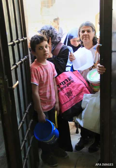 Palestinian families wait to receive a charity meal before the breakfast in the Islamic holy month of Ramadan, in Jerusalem, on June 16, 2016. Muslims around the world celebrate Ramadan, the holy month in the Islamic cal...