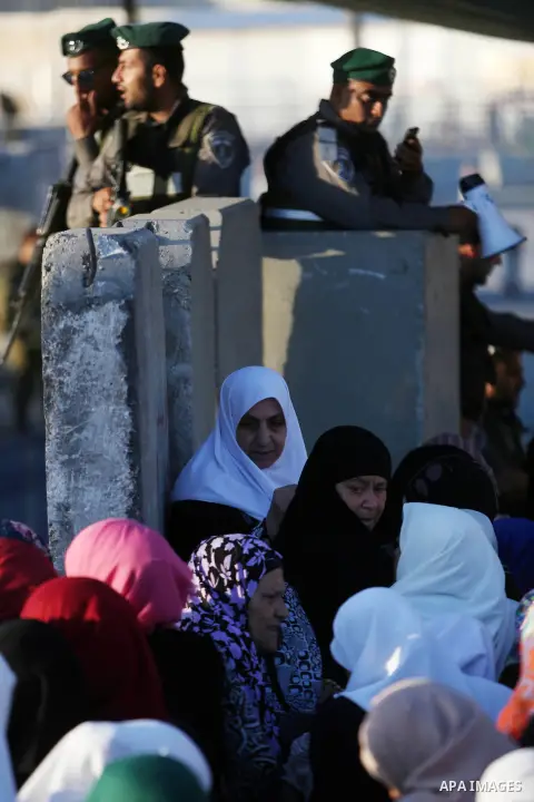 Palestinian women wait to cross the Qalandia checkpoint between the West Bank city of Ramallah and Jerusalem on June 17, 2016, as they head to Jerusalem's Al-Aqsa mosque for the second Friday prayer of the holy Muslim fa...