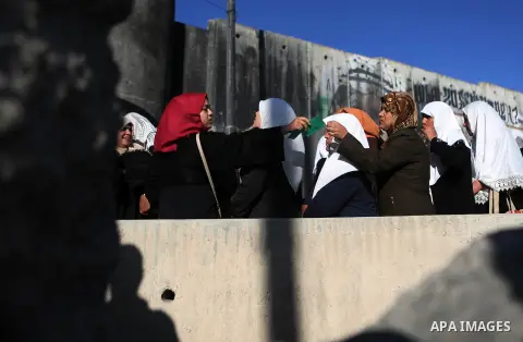 Palestinian women wait to cross the Qalandia checkpoint between the West Bank city of Ramallah and Jerusalem on June 17, 2016, as they head to Jerusalem's Al-Aqsa mosque for the second Friday prayer of the holy Muslim fa...