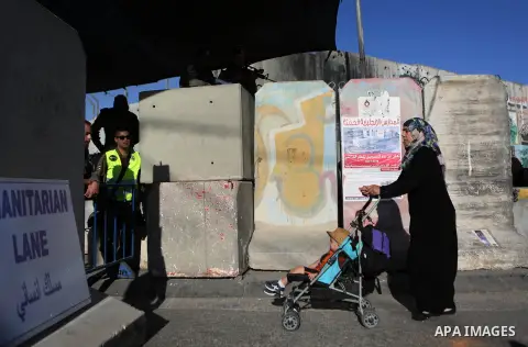 A Palestinian woman cross the Qalandia checkpoint between the West Bank city of Ramallah and Jerusalem on June 17, 2016, as she head to Jerusalem's Al-Aqsa mosque for the second Friday prayer of the holy Muslim fasting m...