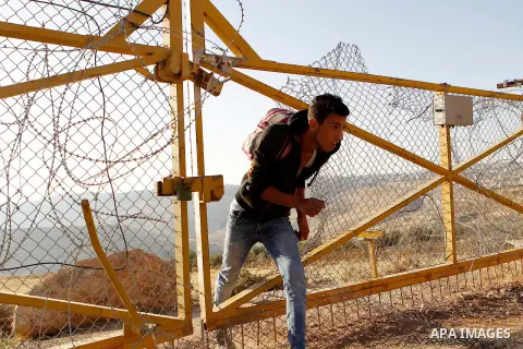 Palestinians, not permitted by Israeli security forces to cross into Jerusalem from the West Bank due to an age limit, climb an Israeli fence between the West Bank town of Bethlehem and Jerusalem as they try to make thei...