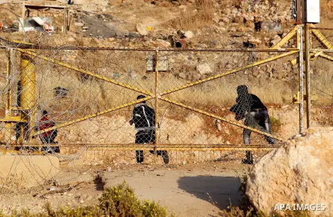Palestinians, not permitted by Israeli security forces to cross into Jerusalem from the West Bank due to an age limit, climb an Israeli fence between the West Bank town of Bethlehem and Jerusalem as they try to make thei...