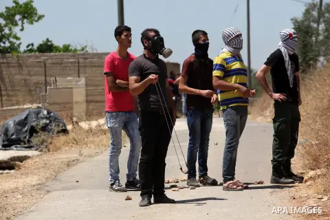 Palestinian protesters look on during clashes with Israeli security forces following a demonstration against the expropriation of Palestinian land by Israel, on June 17, 2016 in the village of Kfar Qaddum, near Nablus, i...