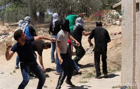 Palestinian protesters hurl stones Israeli security forces during clashes following a demonstration against the expropriation of Palestinian land by Israel, on June 17, 2016 in the village of Kfar Qaddum, near Nablus, in...