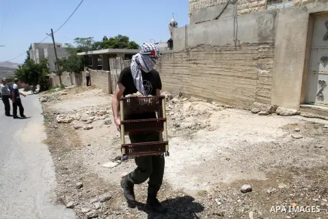 A Palestinian protester carries stones during clashes with Israeli security forces following a demonstration against the expropriation of Palestinian land by Israel, on June 17, 2016 in the village of Kfar Qaddum, near N...