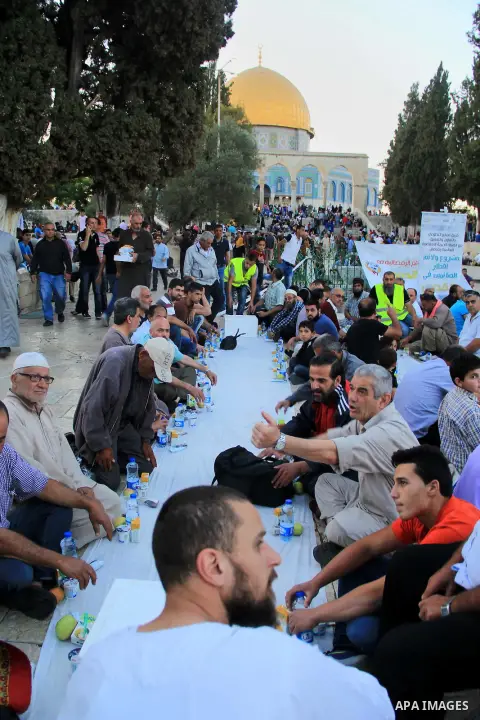 Palestinian muslims take their breakfast during the holy fasting month of Ramadan in front of the Dome of the Rock mosque at the al-Aqsa mosque compound in Jerusalem's old city on June 17, 2016 during the holy fasting mo...