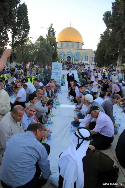 Palestinian muslims take their breakfast during the holy fasting month of Ramadan in front of the Dome of the Rock mosque at the al-Aqsa mosque compound in Jerusalem's old city on June 17, 2016 during the holy fasting mo...
