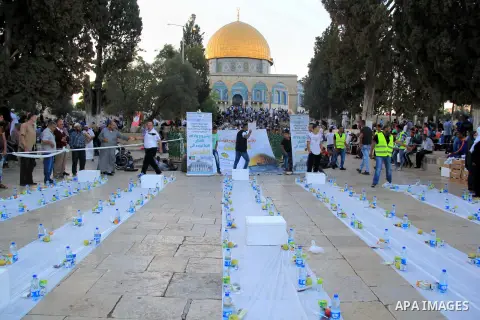 Palestinian muslims prepare to break their fast during the holy fasting month of Ramadan in front of the Dome of the Rock mosque at the al-Aqsa mosque compound in Jerusalem's old city on June 17, 2016 during the holy fas...