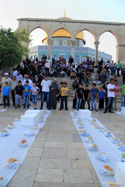 Palestinian muslims prepare to break their fast during the holy fasting month of Ramadan in front of the Dome of the Rock mosque at the al-Aqsa mosque compound in Jerusalem's old city on June 17, 2016 during the holy fas...