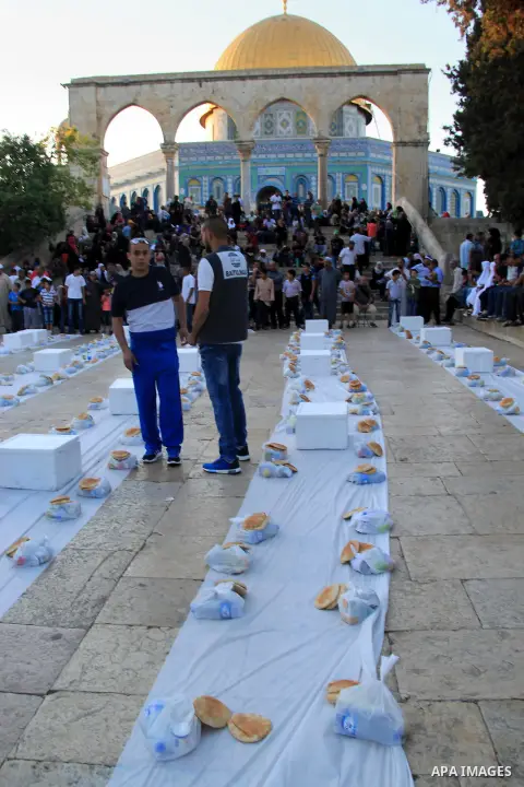 Palestinian muslims prepare to break their fast during the holy fasting month of Ramadan in front of the Dome of the Rock mosque at the al-Aqsa mosque compound in Jerusalem's old city on June 17, 2016 during the holy fas...