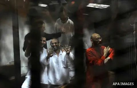 Defendants of Egyptian Muslim Brotherhood sit behind bars during their trial at a court in Cairo on June 18, 2016. An Egyptian court sentenced Morsi to life in prison in an espionage trial in which six co-defendants were...