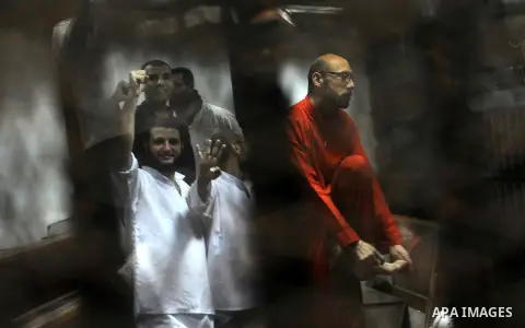 Defendants of Egyptian Muslim Brotherhood sit behind bars during their trial at a court in Cairo on June 18, 2016. An Egyptian court sentenced Morsi to life in prison in an espionage trial in which six co-defendants were...