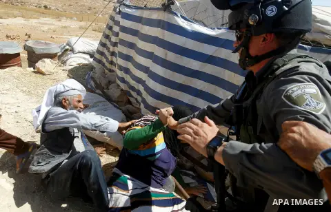 Palestinians scuffle with an Israeli border policeman as Israeli troops demolish sheds belonging to Palestinians near the West Bank village of Yatta, south of Hebron June 19, 2016. Photo by Wisam Hashlamoun