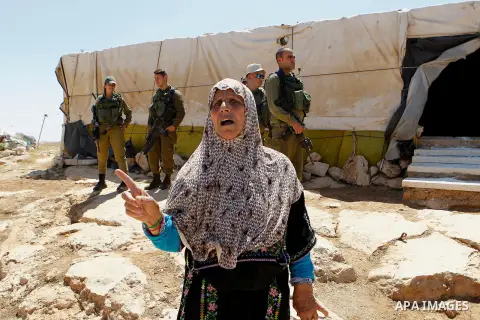An old Palestinian woman reacts as Israeli troops demolish sheds belonging to Palestinians near the West Bank village of Yatta, south of Hebron June 19, 2016. Photo by Wisam Hashlamoun