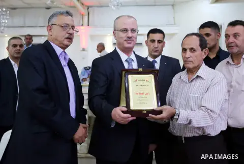 Palestinian Prime Minister Rami Hamdallah takes part during take breakfast on holy fasting month of Ramadan, in the West Bank city of Tulkarem, on June 20, 2016. Photo by Prime Minister Office