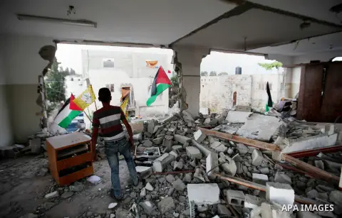 A Palestinian boy inspects the home of the Bashar Masalha that was demolished by the Israeli military in the West bank city of Qalqilya, on June 21, 2016. Bashar Masalha was killed in Jaffa city on 8 March 2016, under th...