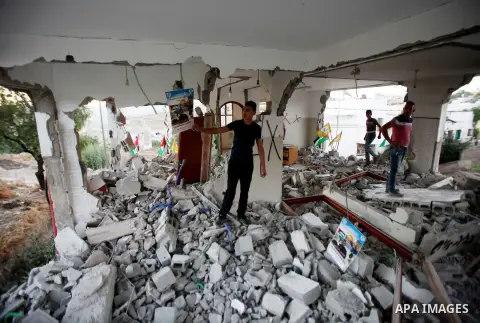 A Palestinian boy inspects the home of the Bashar Masalha that was demolished by the Israeli military in the West bank city of Qalqilya, on June 21, 2016. Bashar Masalha was killed in Jaffa city on 8 March 2016, under th...