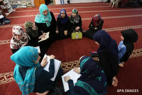 Palestinian blind girls read a copy of the Koran, Islam's holy book, at a religion school in Gaza City on June 21, 2016, during the Muslim fasting month of Ramadan. Photo by Mohammed Asad