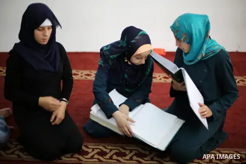 Palestinian blind girls read a copy of the Koran, Islam's holy book, at a religion school in Gaza City on June 21, 2016, during the Muslim fasting month of Ramadan. Photo by Mohammed Asad