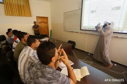 A Palestinian imam uses sign-language to teach the Koran, Islam's holy book, to deaf students at a religion school in Gaza City on June 21 2016, during the Muslim fasting month of Ramadan. Photo by Mohammed Asad