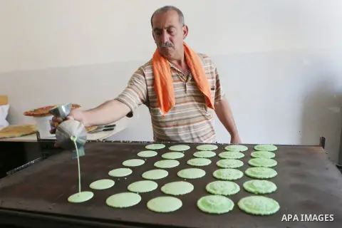 A Palestinian man prepares traditional pancakes known as ''Qatayef" at his shop during the Muslim holy fasting month of Ramadan in the West Bank village of Ein Yabrud near Ramallah on June, 21, 2016. Ramadan is sacred to...