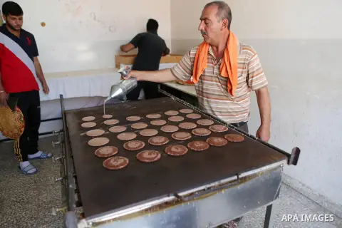 A Palestinian man prepares traditional pancakes known as ''Qatayef" at his shop during the Muslim holy fasting month of Ramadan in the West Bank village of Ein Yabrud near Ramallah on June, 21, 2016. Ramadan is sacred to...