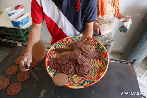 A Palestinian man prepares traditional pancakes known as ''Qatayef" at his shop during the Muslim holy fasting month of Ramadan in the West Bank village of Ein Yabrud near Ramallah on June, 21, 2016. Ramadan is sacred to...