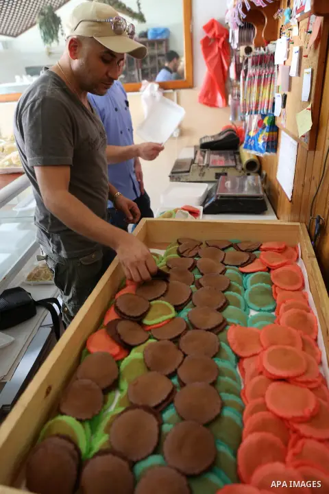 A Palestinian man prepares traditional pancakes known as ''Qatayef" at his shop during the Muslim holy fasting month of Ramadan in the West Bank village of Ein Yabrud near Ramallah on June, 21, 2016. Ramadan is sacred to...