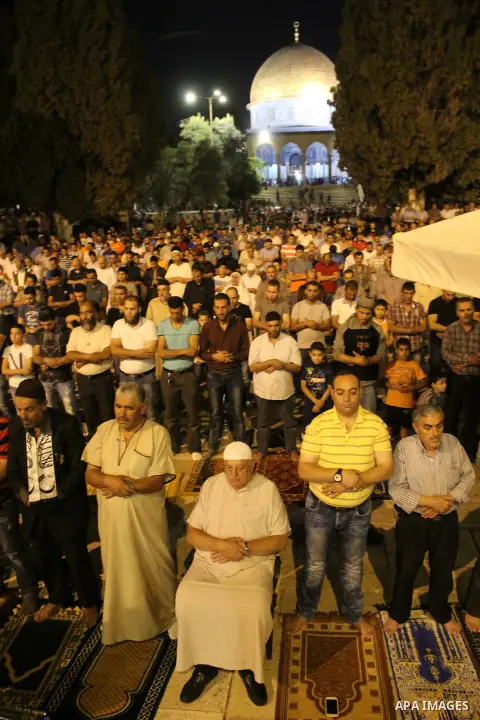 Palestinian Muslim worshippers perform "Taraweeh", nightly prayer of the month of Ramadan, in front of the Dome of the Rock mosque, in Jerusalem's old city on June 21, 2016. Ramadan is sacred to Muslims because it is dur...
