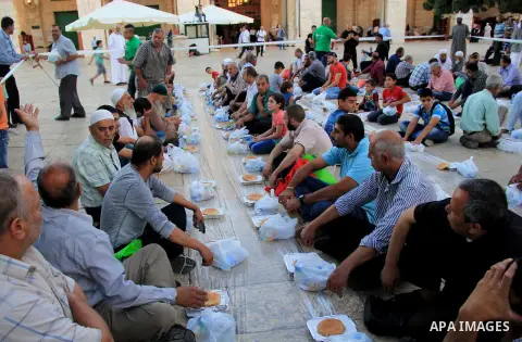 Palestinian muslims prepare to break their fast during the holy fasting month of Ramadan in front of the Dome of the Rock mosque at the al-Aqsa mosque compound, in Jerusalem's old city on June 21, 2016. Ramadan is sacred...