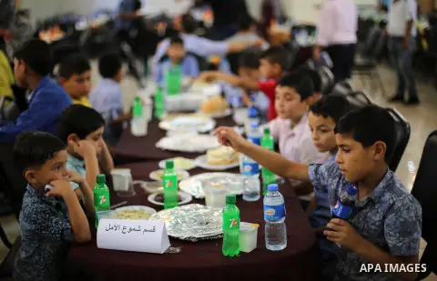 Palestinian orphan children break their fast during the holy fasting month of Ramadan in Gaza city on June 22, 2016. Ramadan is sacred to Muslims because it is during that month that tradition says the Koran was revealed...