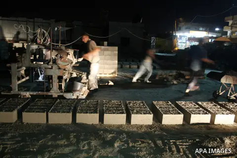 Palestinian labourers work at a cement factory at night to avoid the day time heat in Rafah in the southern Gaza Strip on June 22, 2016 during Islam's holy fasting month of Ramadan. Ramadan is sacred to Muslims because i...