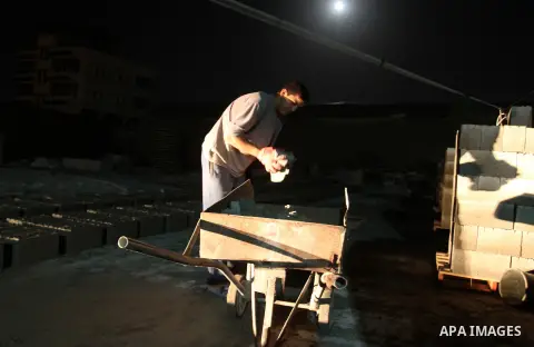 Palestinian labourers work at a cement factory at night to avoid the day time heat in Rafah in the southern Gaza Strip on June 22, 2016 during Islam's holy fasting month of Ramadan. Ramadan is sacred to Muslims because i...