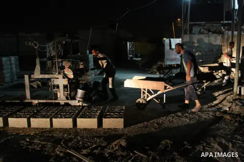 Palestinian labourers work at a cement factory at night to avoid the day time heat in Rafah in the southern Gaza Strip on June 22, 2016 during Islam's holy fasting month of Ramadan. Ramadan is sacred to Muslims because i...
